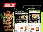 Gorillas app displayed on two smartphones with a grocery delivery box featuring fresh fruits and vegetables, highlighting convenient online shopping for groceries.