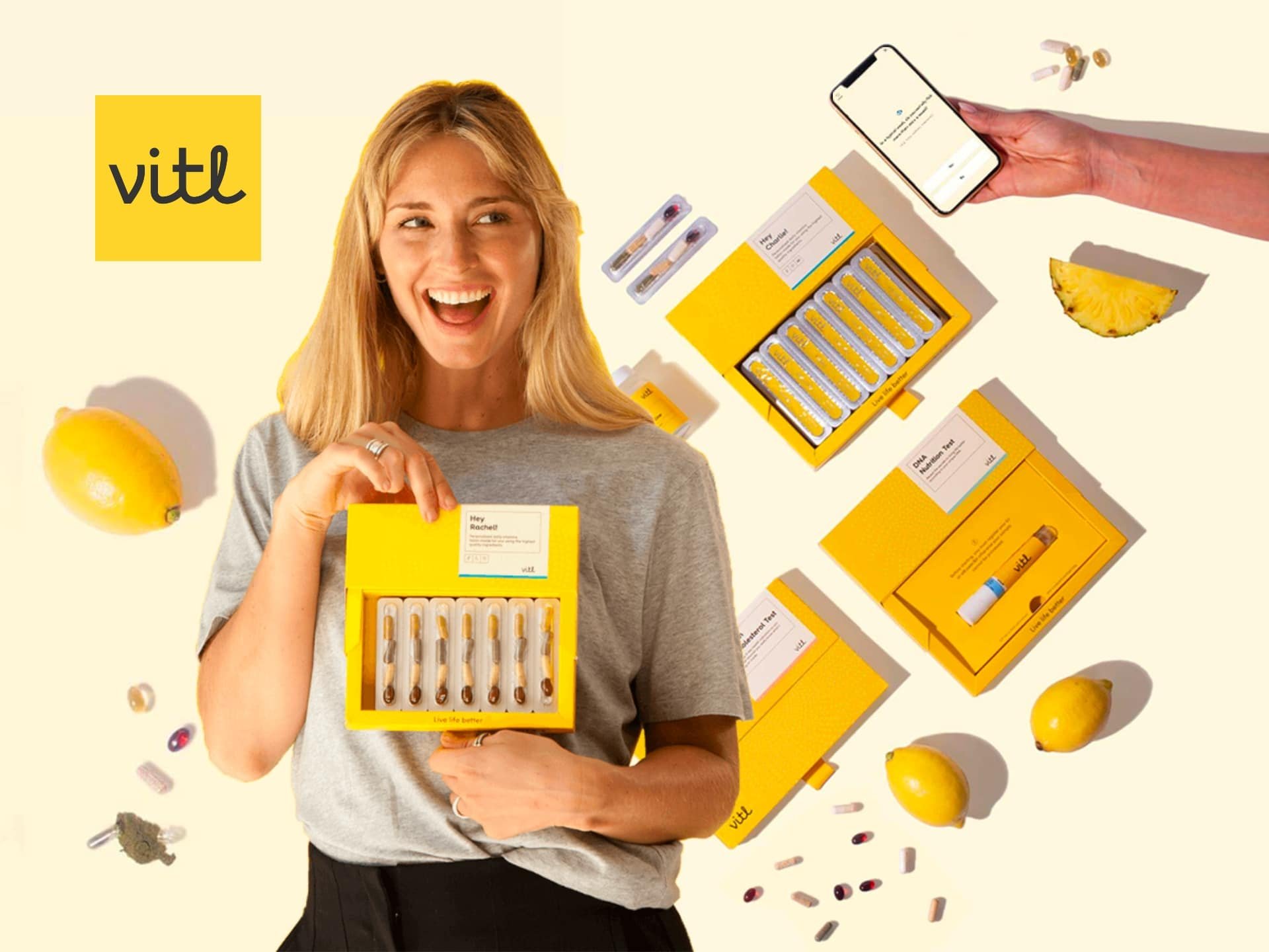 Smiling woman holding a box of personalized vitamins from Vitl, surrounded by vitamin packs and a smartphone displaying the Vitl app, showcasing a modern health and wellness lifestyle.
