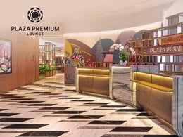 Modern interior of Plaza Premium Lounge featuring a stylish reception area with elegant decor, vibrant wall art, and polished flooring, designed for travelers seeking comfort and relaxation.
