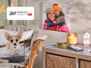 Cozy living room scene featuring a decorative pillow with a corgi design, a stylish wicker chair, and a wooden side table adorned with a candle and a photo canvas of a smiling woman and child in winter attire. Ideal for home decor inspiration and personalized photo displays.
