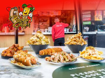 A vibrant food stall featuring a variety of delicious dishes, including loaded fries, gourmet hot dogs, and crispy chicken, with a chef preparing food in the background. The stall is decorated with colorful graphics that highlight the menu offerings.