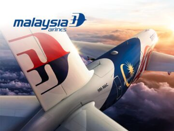 Malaysia Airlines aircraft flying above the clouds, showcasing the airline's logo and vibrant tail design against a sunset backdrop.