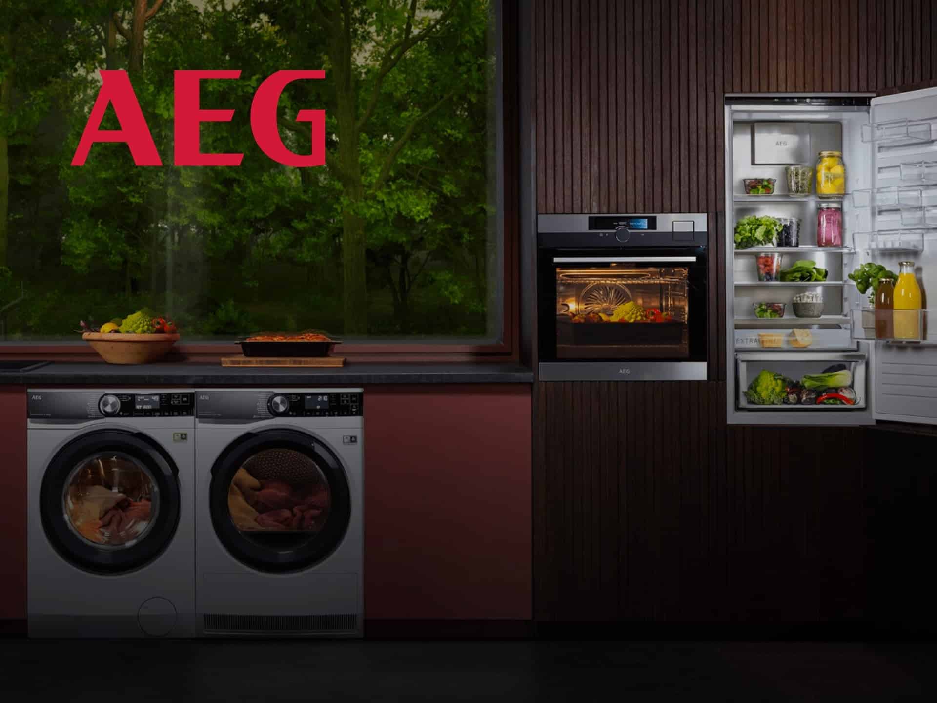 Modern Kitchen Featuring Aeg Appliances, Including A Washing Machine, Oven, And Refrigerator, With A View Of Greenery Through The Window.