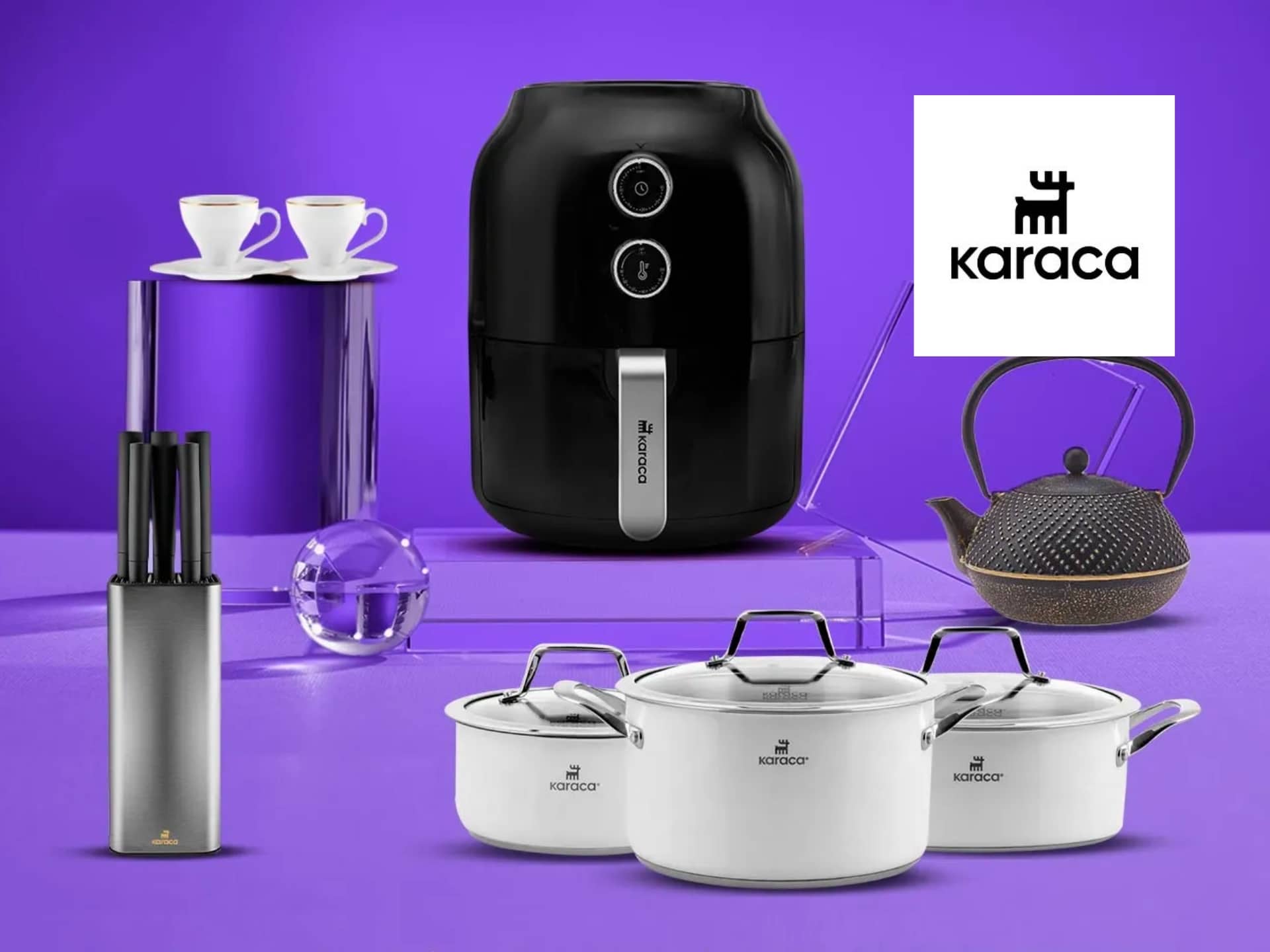 Modern Kitchen Appliances And Cookware Displayed On A Vibrant Purple Background, Featuring An Air Fryer, White Cooking Pots, A Knife Set, A Teapot, And Coffee Cups, With The Karaca Logo Prominently Featured.