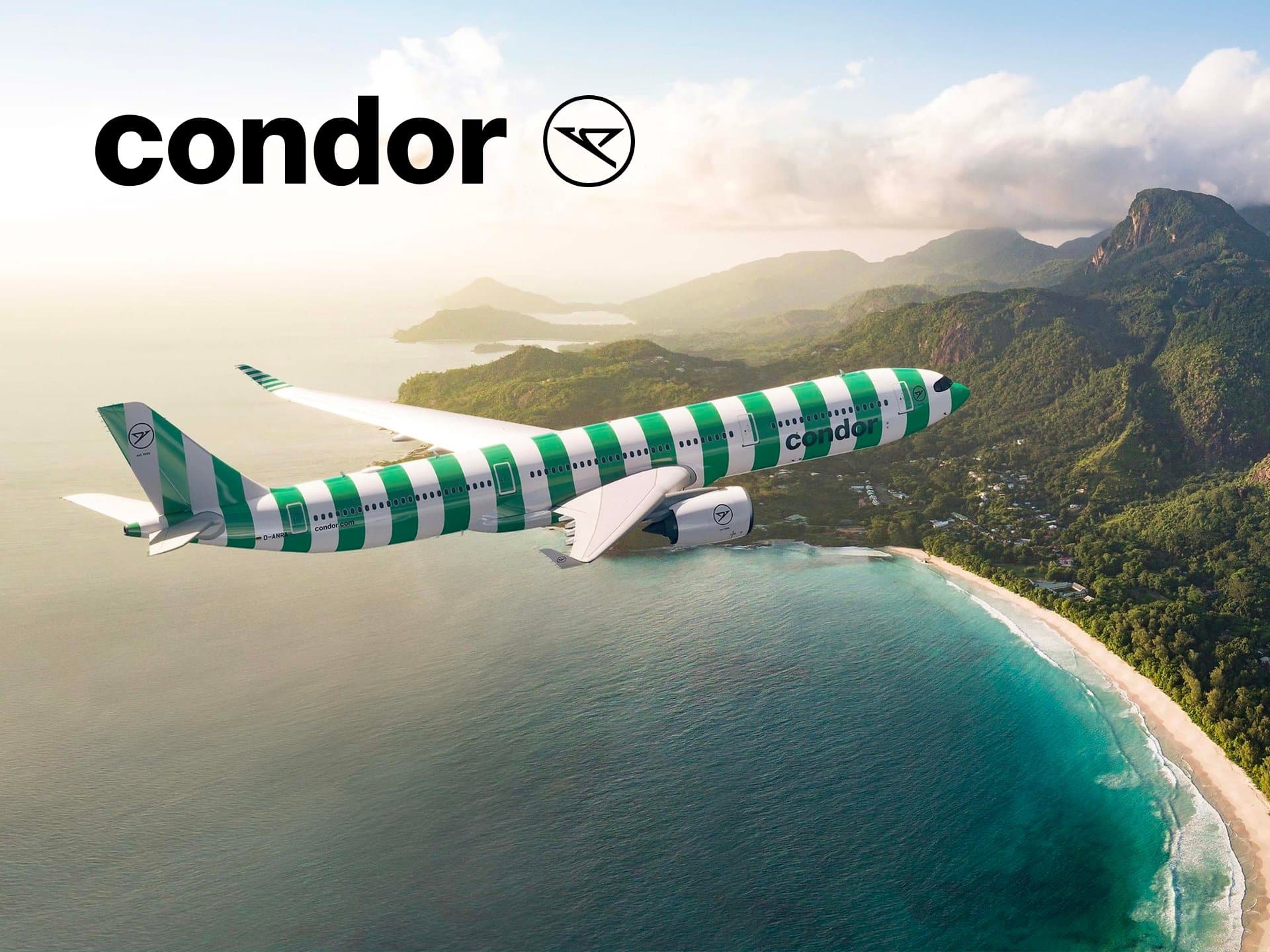 Condor Airlines Aircraft Flying Over A Scenic Coastal Landscape, Showcasing The Airline'S Distinctive Green And White Striped Livery Against A Backdrop Of Mountains And Ocean.