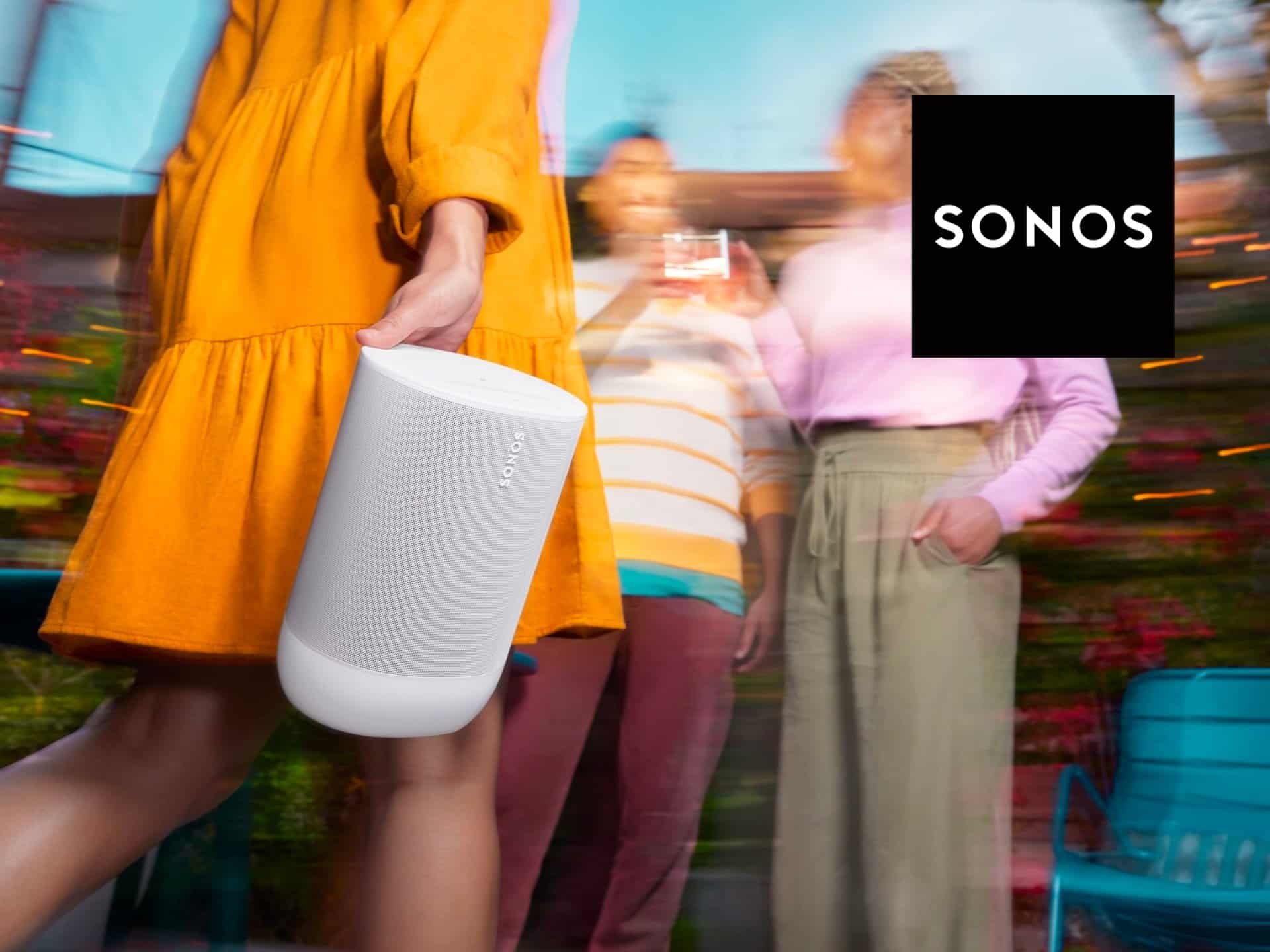A Person In A Vibrant Yellow Dress Carries A Portable Sonos Speaker At An Outdoor Gathering, Surrounded By Friends Enjoying Music And Socializing In A Colorful Setting.