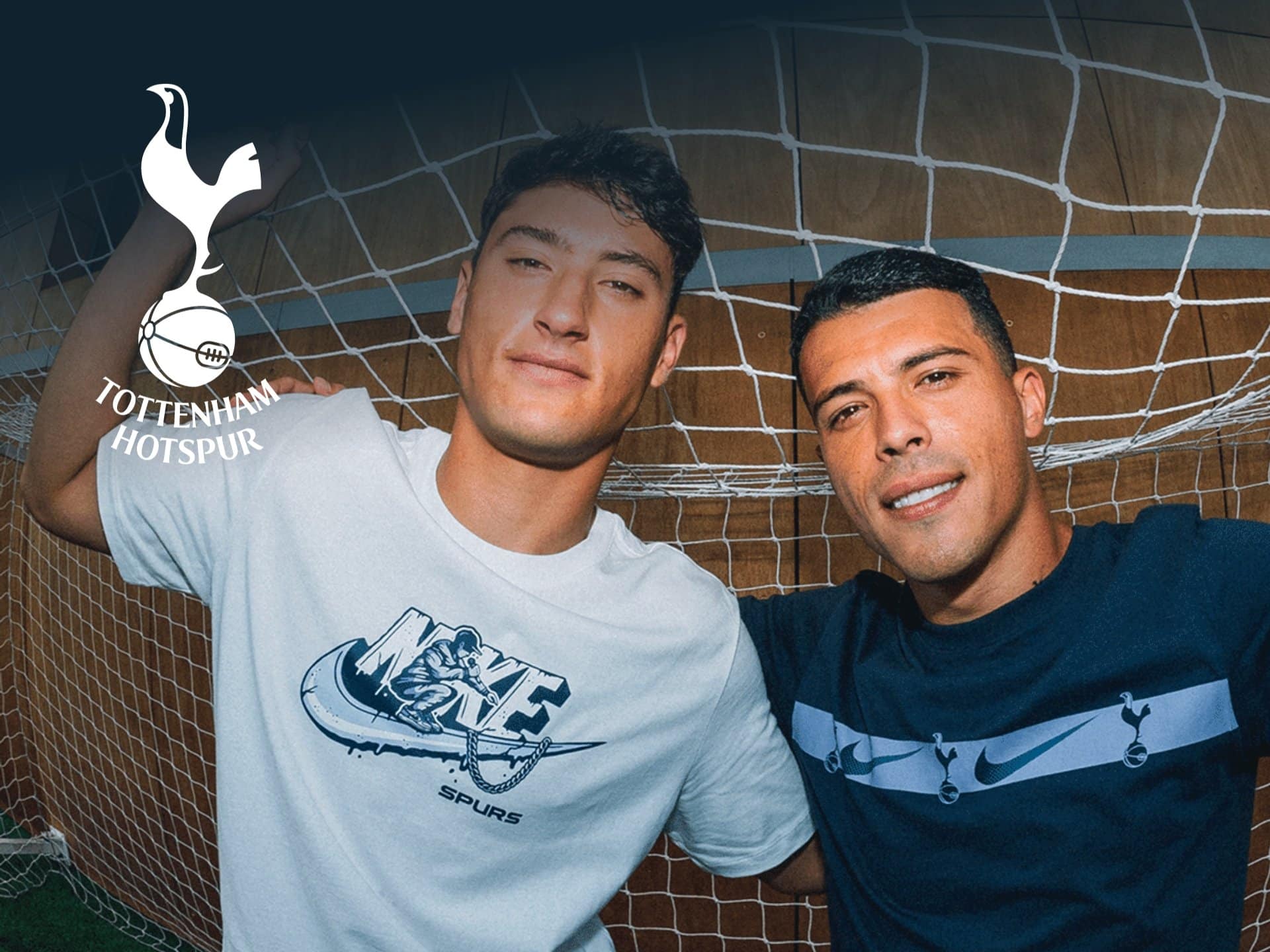 Two young men posing together in front of a soccer goal, wearing Tottenham Hotspur jerseys. The Tottenham Hotspur logo is visible in the top left corner. The scene captures a lively atmosphere, highlighting their enthusiasm for soccer.