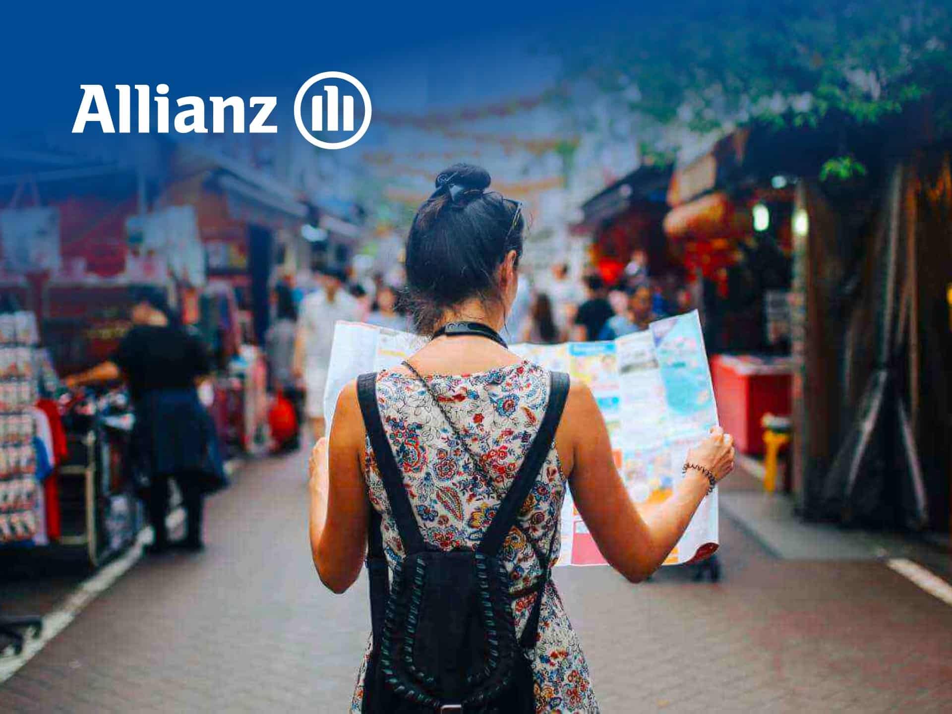 Person Holding A Map While Exploring A Vibrant Market, With Allianz Logo In The Corner, Highlighting Travel And Insurance Services.