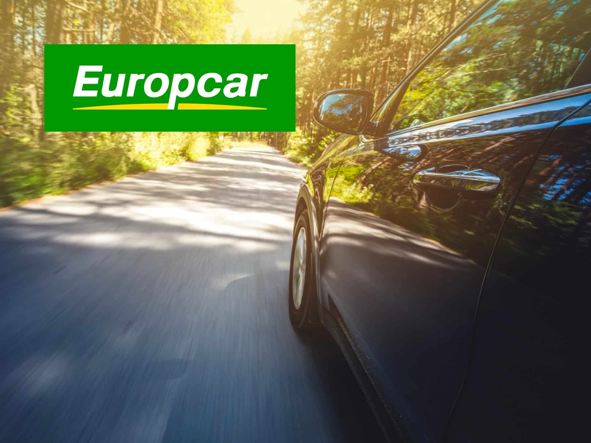 Car Driving On A Scenic Road With Europcar Logo, Representing Car Rental Services And Travel Experiences.