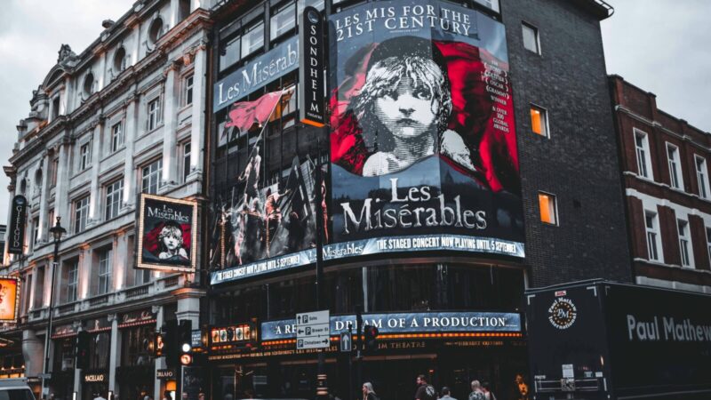 Facade of Sondheim Theatre in London displaying Les Misérables posters.